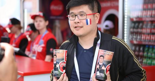 Guy tenant deux verres souvenir de Coca-Cola à la Coupe du Monde de la FIFA 2018