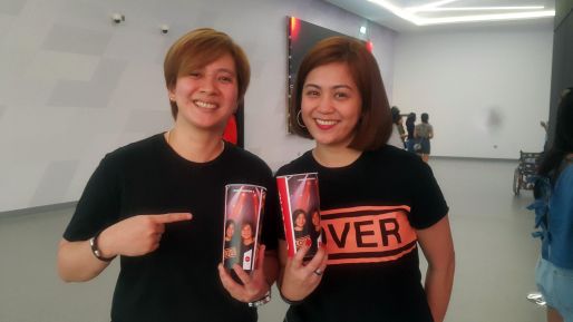 Two guests holding personalized plastic Coca-Cola cups at Maroon 5 Concert at Coca-Cola Arena 2019